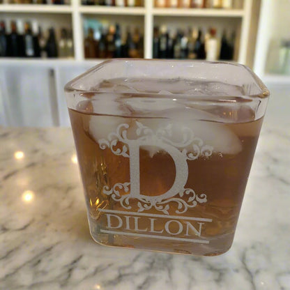 square on the rocks glass filled with whiskey and ice with the engraving "Dillon" on the side