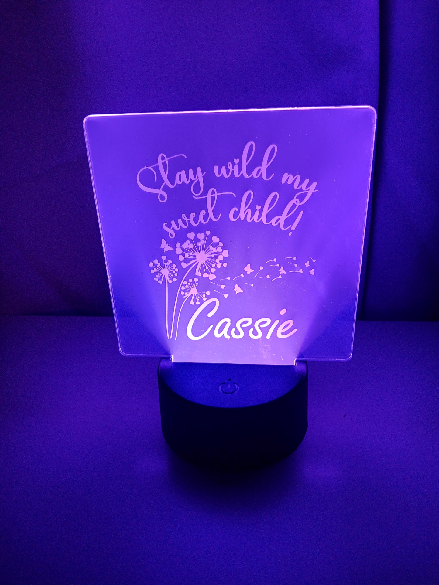 Personalized LED acrylic light with "Stay wild my sweet child" and the name "Cassie" engraved, illuminated in purple.