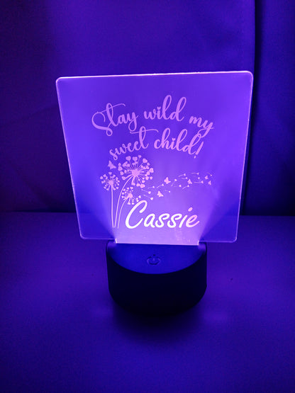 Personalized LED acrylic light with "Stay wild my sweet child" and the name "Cassie" engraved, illuminated in purple.