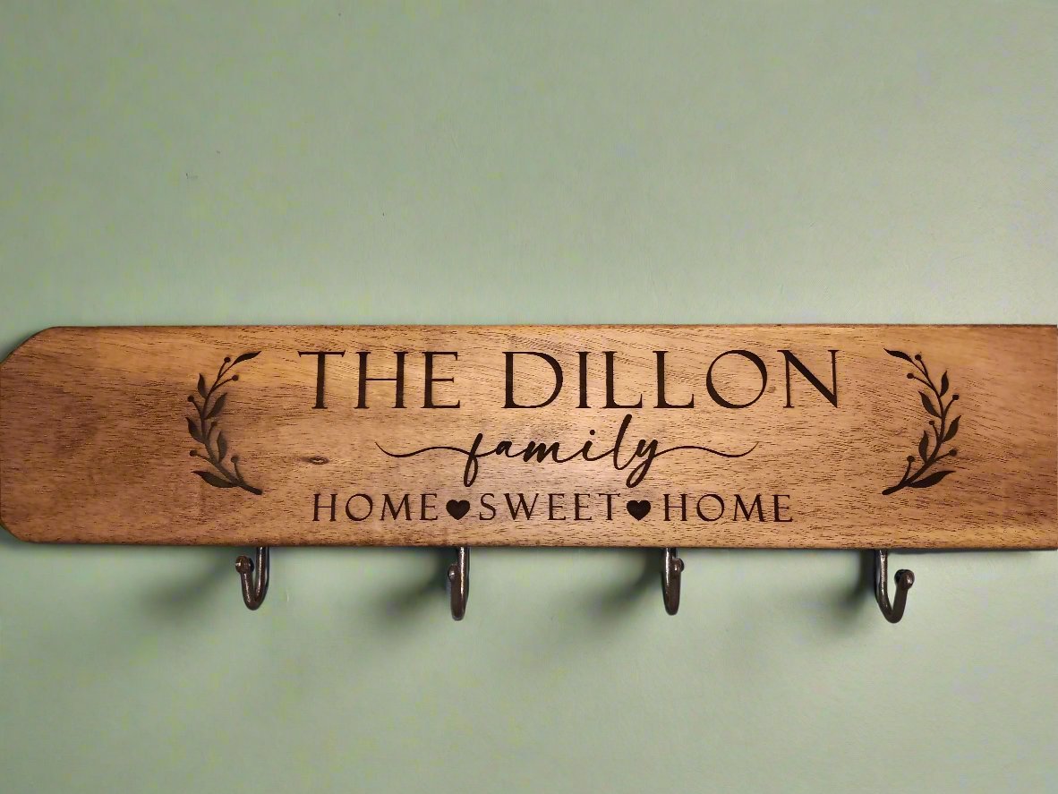 Wooden coffee mug holder with text "The Dillon Family, Home Sweet Home" and featuring metal hooks for hanging mugs.