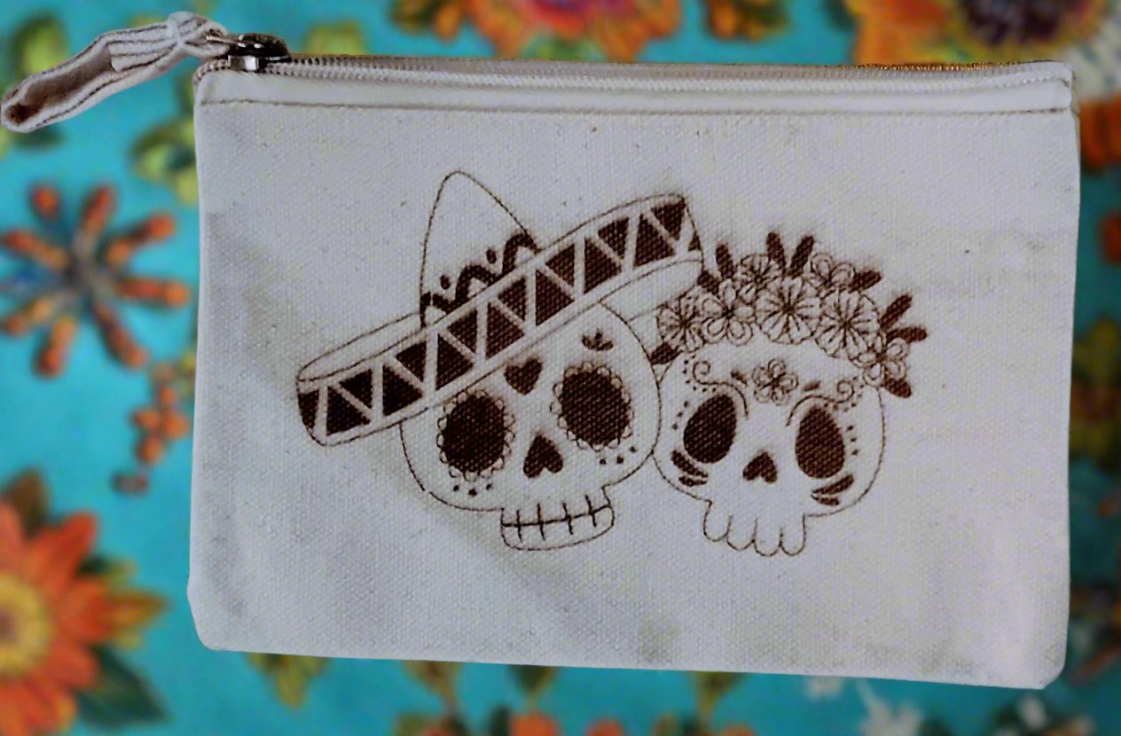 Small change purse with Day of the Dead skulls design; one wearing a sombrero, the other adorned with flowers.