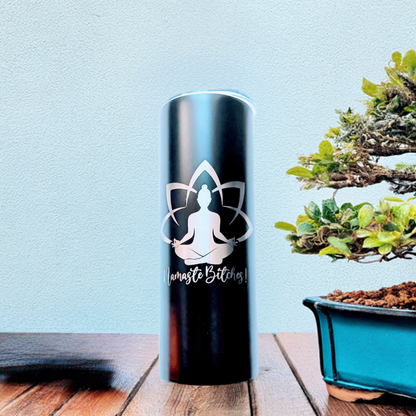 Namaste Tumbler on a wooden surface, featuring a serene design with yoga symbols and text beside a bonsai tree in the background.