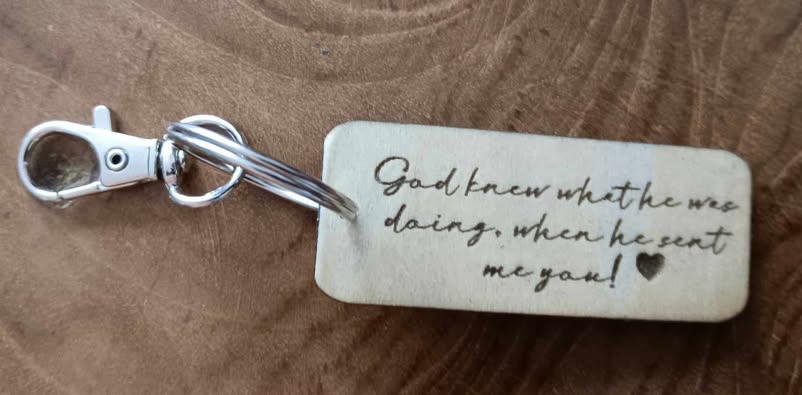 a wooden keychain displaying the phrase "God knew what he was doing when he sent me you!"