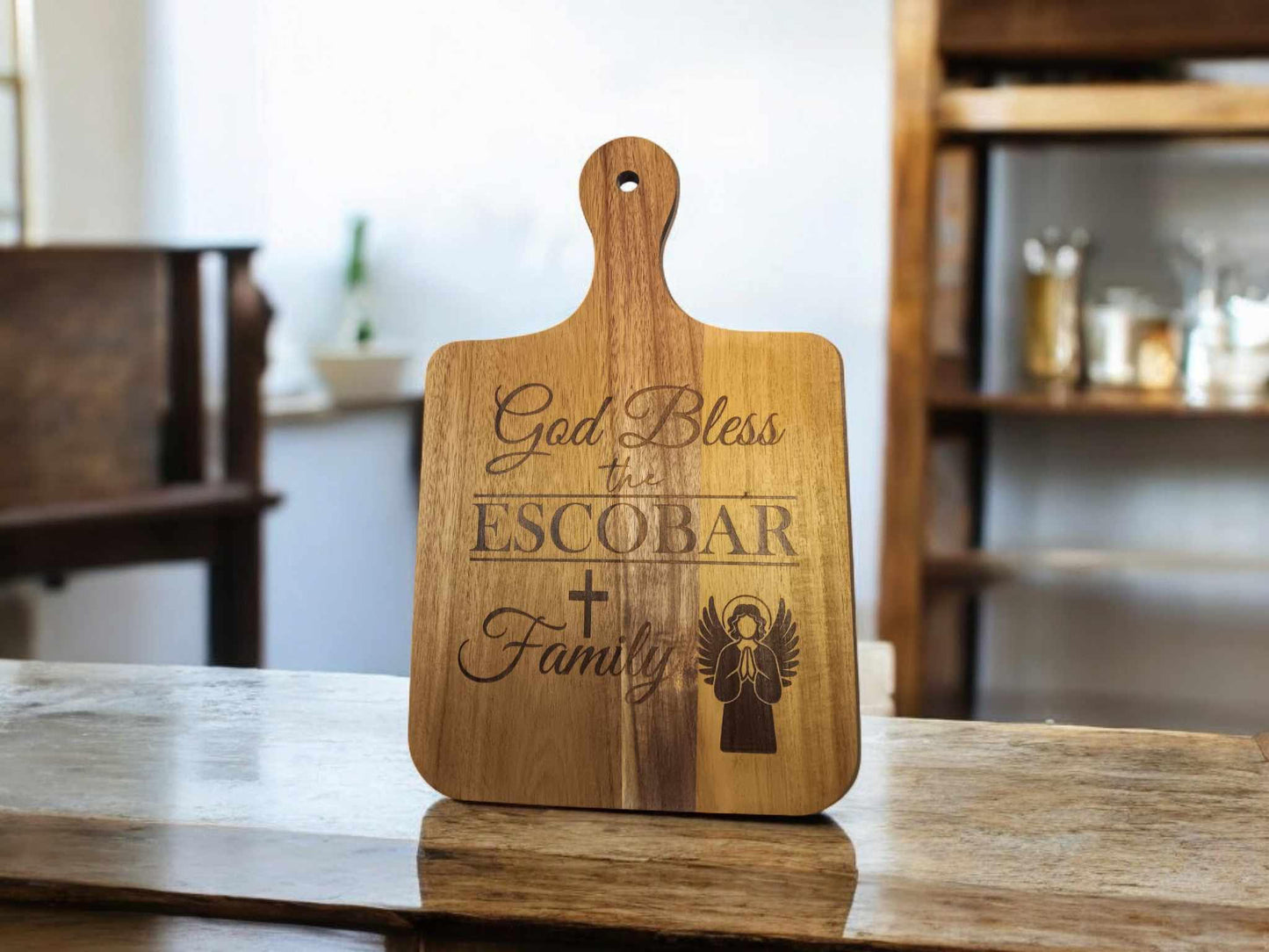 16x10 personalized cutting board with "God Bless the Escobar Family" and decorative symbols etched on it, displayed in a kitchen.