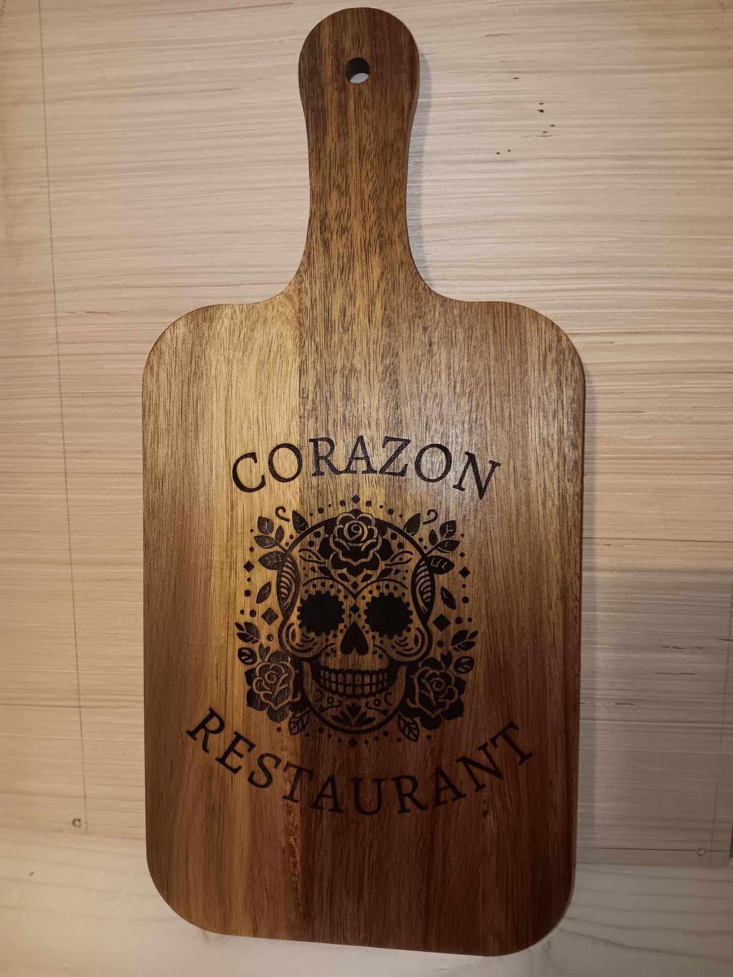 13x7 personalized cutting board with "Corazon Restaurant" and a decorative skull engraving displayed on product page.