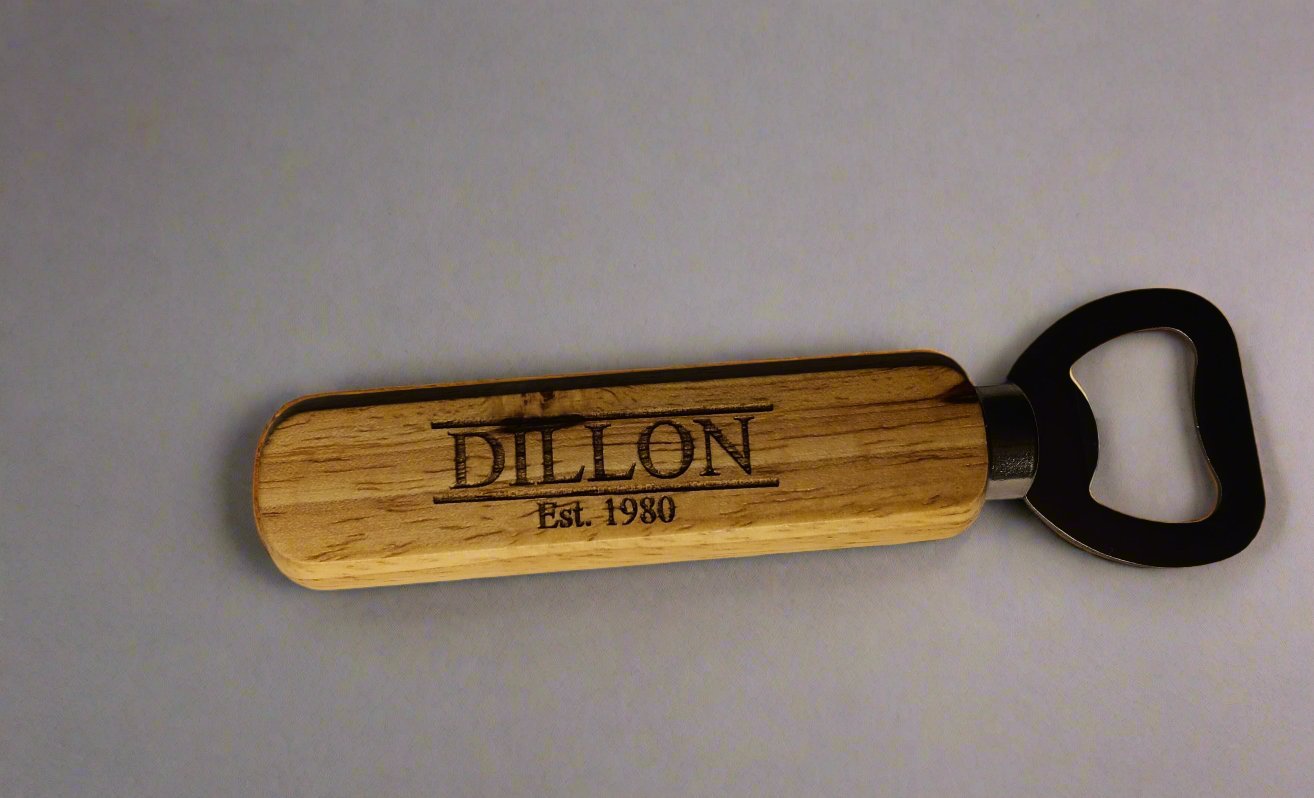 wood handled bottle opener with the text "dillon est. 1980" engraved in the handle.